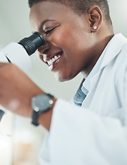 Image showing Making informed decisions based off his thorough research. a young woman using a microscope in a lab.