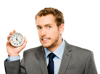 Image showing Hes always on the clock. a businessman holding a clock against a studio background.