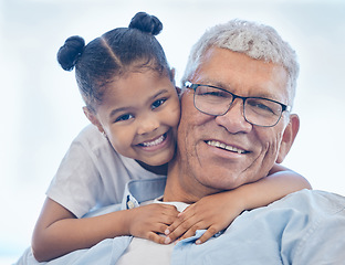 Image showing Grandpa and granddaughter smiling while spending quality time together. Loving little girl hugging her grandfather. Senior man with grey hair and glasses bonding with his grandchild