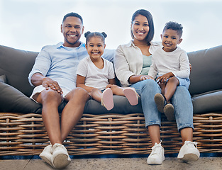 Image showing Happy young mixed race family smiling looking cheerful and relaxing on the couch together at home. Two hispanic parents enjoying a day with their little children at home one the weekend