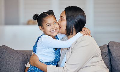 Image showing Mixed race woman kissing her adorable little daughter on the cheek while bonding together at home. Small girl feeling special and looking happy to be getting love, affection and quality time with mom