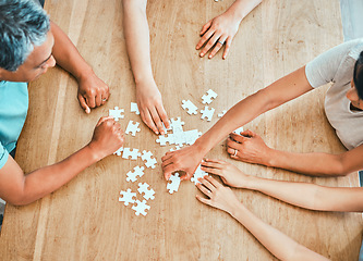 Image showing We have all the pieces. a family building a puzzle together at home.