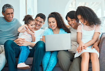 Image showing Family never loses its magic. a beautiful family using a laptop while bonding on a sofa at home.