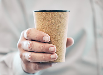 Image showing The fuel for success. an unrecognizable businessman holding a takeaway coffee while standing in his office.