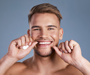 Image showing You want to look your best to feel your best. Studio shot of a handsome young man flossing his teeth against a grey background.