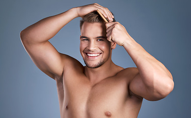 Image showing Go take care of yourselves. a handsome young man combing his hair.