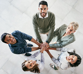 Image showing Don’t wish it were easier. Wish you were better. High angle shot of a group of young businesspeople joining hands in solidarity in a modern office.