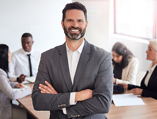 Image showing Hes got this covered. a mature businessman standing with his arms crossed during a meeting at work.