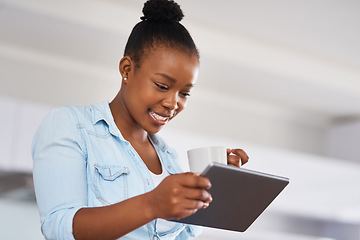 Image showing Im definitely sharing this post. a woman drinking coffee while using a digital tablet at home.