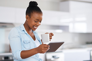 Image showing I love that technology keeps me in the know. a woman drinking coffee while using a digital tablet at home.