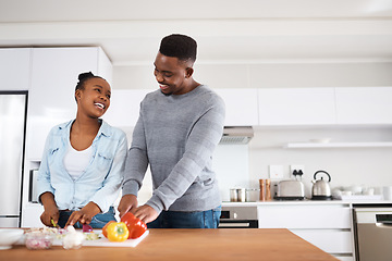 Image showing I love how youre always helping around the house. a young couple cooking together at home.