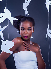 Image showing Beauty is a radiance that originates from within. Studio portrait of a beautiful young woman posing with paper birds against a black background.