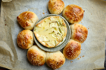 Image showing closeup of freshly baked bread buns with melted brie