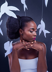 Image showing Go forth and dazzle. Studio shot of a beautiful young woman posing with paper birds against a black background.