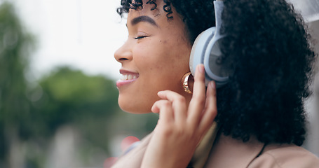 Image showing Businesswoman, headphones and listening to music with eyes closed on street, city or outside by commute. African person, curly hair and smile for podcast, streaming or radio with internet, web or app