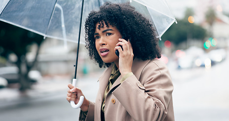 Image showing Businesswoman, worry and phone for talking in city for commute to work by walking with umbrella for rain. African person, manager and serious face while late for career, job or meeting with client