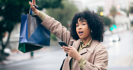 Image showing Woman, call or wave with hand for taxi by holding phone with shopping bag on street for travel. African person, manager and late for meeting, appointment or work in city with transportation commute