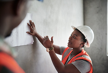 Image showing Builders do it without boardrooms. a young man and woman going over building plans at a construction site.