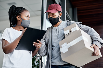 Image showing Excellent delivery service Ill sign for that. a masked young woman signing for a delivery received at home.