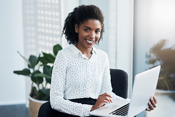 Image showing I do business wirelessly. a young businesswoman using a laptop in a modern office.