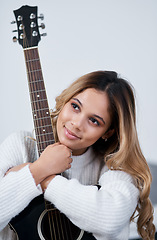 Image showing I have a passion for music. a young woman sitting at home with her guitar.