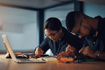 Image showing Combined expertise gets the computer repaired quicker. two young technicians repairing computer hardware together.