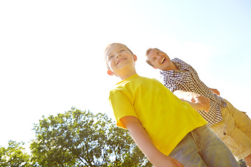 Image showing Whats over there, dad. Cute young boy smiling widely outdoors with his dad.