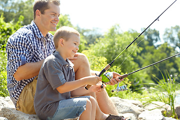 Image showing Fishing in the sunshine with dad. Side view of a father sitting and fishing with his son.