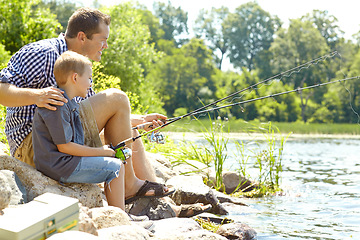 Image showing Relaxing beside the lake with my son. Young father sitting beside his son and fishing.