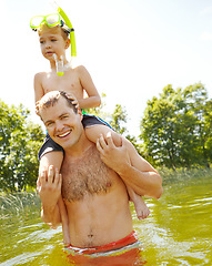 Image showing Playing in the lake with my son. Young father standing in a lake carrying his son on his shoulders and smiling.