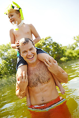 Image showing Lazing in the lake with dad. Young father in a lake carrying his son on his shoulders while smiling.