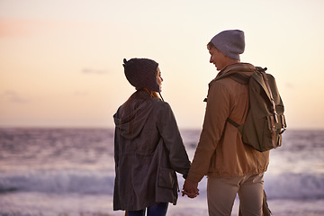 Image showing Love so deep that the sea would be envious. a young couple enjoying a romantic evening on the beach at sunset.