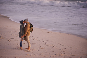 Image showing Love starts with a kiss. a young couple enjoying a romantic kiss on the beach at sunset.
