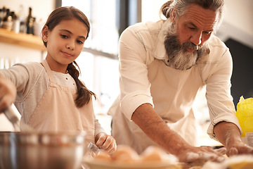 Image showing Partners in baking. a girl and her grandfather baking together in the kitchen.