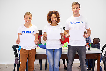 Image showing Helping is its own reward. Portrait of volunteers holding up a blank sign while working with little children.
