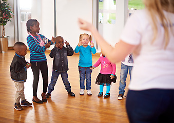 Image showing Every child needs someone to look up to. a volunteer working with little children.