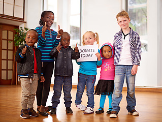 Image showing Make our day. a group of children holding up a donate today sign.
