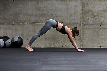 Image showing Fit woman in a modern gym working flexibility and strength through various exercises, demonstrating her commitment to fitness