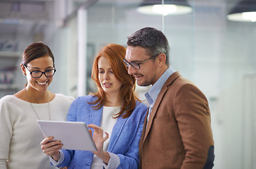 Image showing What do you think. three businesspeople working on a digital tablet.