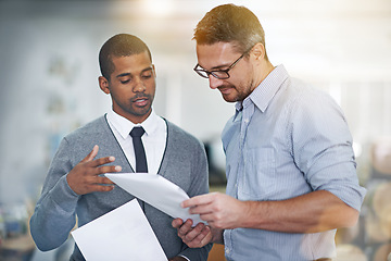 Image showing Sharing his ideas. two businessmen discussing paperwork.