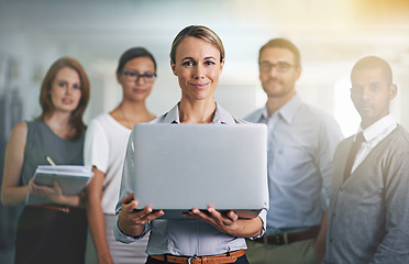 Image showing The secret to business success. Portrait of a businesswoman holding a laptop with her colleagues blurred in the background.