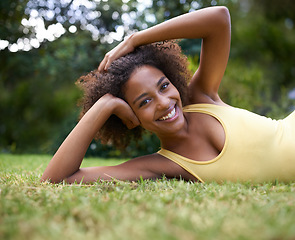Image showing Hanging out in the park. Portrait of a happy young woman lying on the grass in a park.