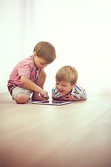 Image showing Playtime gone digital. two little boys using a digital tablet together while sitting on the floor.