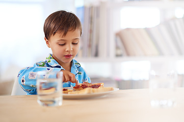 Image showing Breakfast is important for a growing boy. A cute little boy eating breakfast.