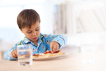 Image showing Time to get my breakfast on. A cute little boy eating breakfast.