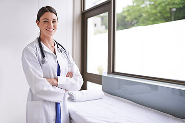 Image showing Her expertise keeps your health sound. A smiling young doctor standing in a clinic.