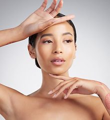 Image showing A beautiful young mixed race woman with glowing skin posing against grey copyspace background. Young confident woman doing a routine selfcare grooming routine with glowing radiant skin