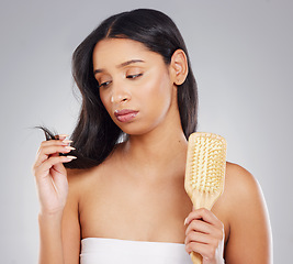 Image showing This just wont do. an attractive young woman looking unhappy with her hair in studio against a grey background.