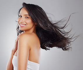 Image showing Sleek, smooth and glossy hair. Cropped portrait of an attractive young woman posing in studio against a grey background.