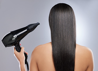 Image showing Time to get a blowout. Rearview shot of a woman with sleek hair holding a hairdryer.